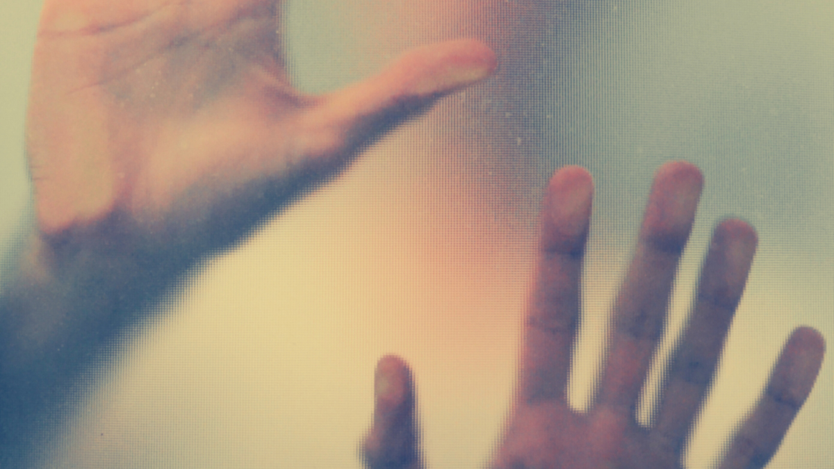 Un homme qui a les mains posées sur une paroi en verre